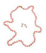 ϒ A coral bead necklace, the single strand of 6mm coral beads, to the spherical clasp, stamped 750,