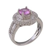 A pink sapphire and diamond cluster ring, the circular cut pink sapphire claw set within a