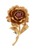 A 1960s 18 carat gold ruby flower head brooch, the flower with a textured finish, set with a cluster