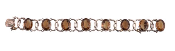 A citrine bracelet, the oval cut citrines in collet settings, with interlocking polished C shaped