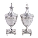 A pair of George III silver urn shaped condiment jars and covers, unmarked, circa 1780, with urn