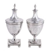 A pair of George III silver urn shaped condiment jars and covers, unmarked, circa 1780, with urn