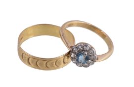 A diamond and aquamarine cluster ring, the circular cut aquamarine surrounded by eight cut diamonds,