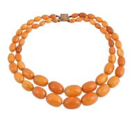A Baltic amber bead necklace, the two rows of graduated amber beads measuring 9.2mm to 26mm, the