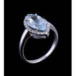 An aquamarine and diamond ring, the marquise cut aquamarine claw set within a surround of