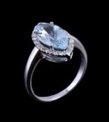 An aquamarine and diamond ring, the marquise cut aquamarine claw set within a surround of