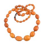 A graduated amber bead necklace, the forty three beads measuring 10mm to 25mm wide, to a barrel