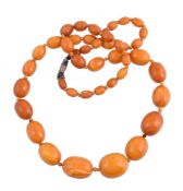 A graduated amber bead necklace, the forty three beads measuring 10mm to 25mm wide, to a barrel