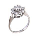A diamond cluster ring, the central brilliant cut diamond in a claw setting, within a surround of