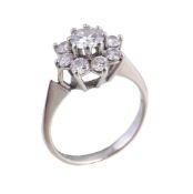 A diamond cluster ring, the central brilliant cut diamond in a claw setting, within a surround of