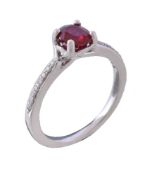 A ruby and diamond ring, the oval cut ruby claw set between brilliant cut diamond set shoulders,