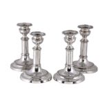 A set of four old Sheffield plate circular telescopic candlesticks, one marked with a hand, circa