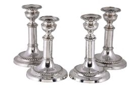 A set of four old Sheffield plate circular telescopic candlesticks, one marked with a hand, circa
