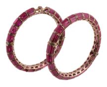 A pair of 1970s synthetic ruby bangles, the baguette cut synthetic rubies within channel settings,