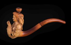 A meerschaum cheroot pipe, circa 1900, carved as a half lady in traditional dress holding a