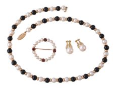 A cultured pearl and garnet brooch, the circlet of cultured pearls with four circular cut garnets,