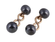 A pair of hematite cufflinks, the polished hematite terminals with gold coloured figure of eight