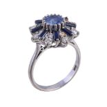 An 18 carat gold sapphire and diamond cluster ring, the central oval cut sapphire claw set within