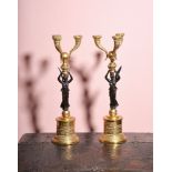 A pair of gilt and patinated bronze three light figural candelabra in Empire taste