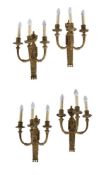 A set of four gilt metal three light wall appliques in Neoclassical taste