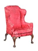 A George II walnut and upholstered wing armchair