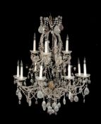 A wrought iron and cut glass adorned twelve light chandelier in Louis XV style