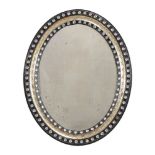An ebonised and parcel gilt oval wall mirror in Irish Regency style