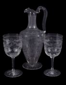 A Stourbridge engraved claret jug and two goblets ensuite