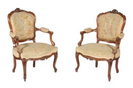 A pair of carved walnut and tapestry upholstered armchairs