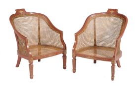 A pair of gilt and red lacquer bergere armchairs in Regency style