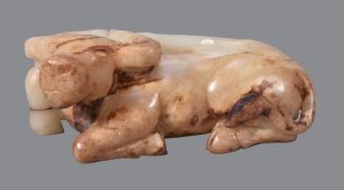A Chinese brown and white jade model of a buffalo