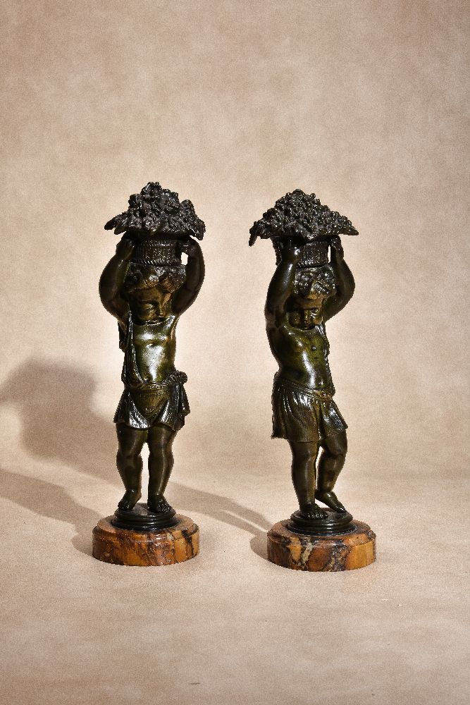 A pair of patinated bronze and marmo convento Siena mounted models of putti