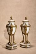 A pair of gilt bronze mounted white marble urns in Louis XVI style
