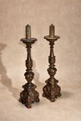 A pair of Italian carved and giltwood altar sticks