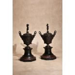 A pair of French patinated bronze and marble mounted twin handled urns and covers