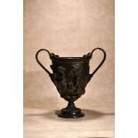 A patinated bronze twin handled urn in Neoclassical style