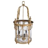 A substantial gilt bronze and glazed three light hall lantern in Regency taste