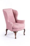 A George II walnut and upholstered wing armchair