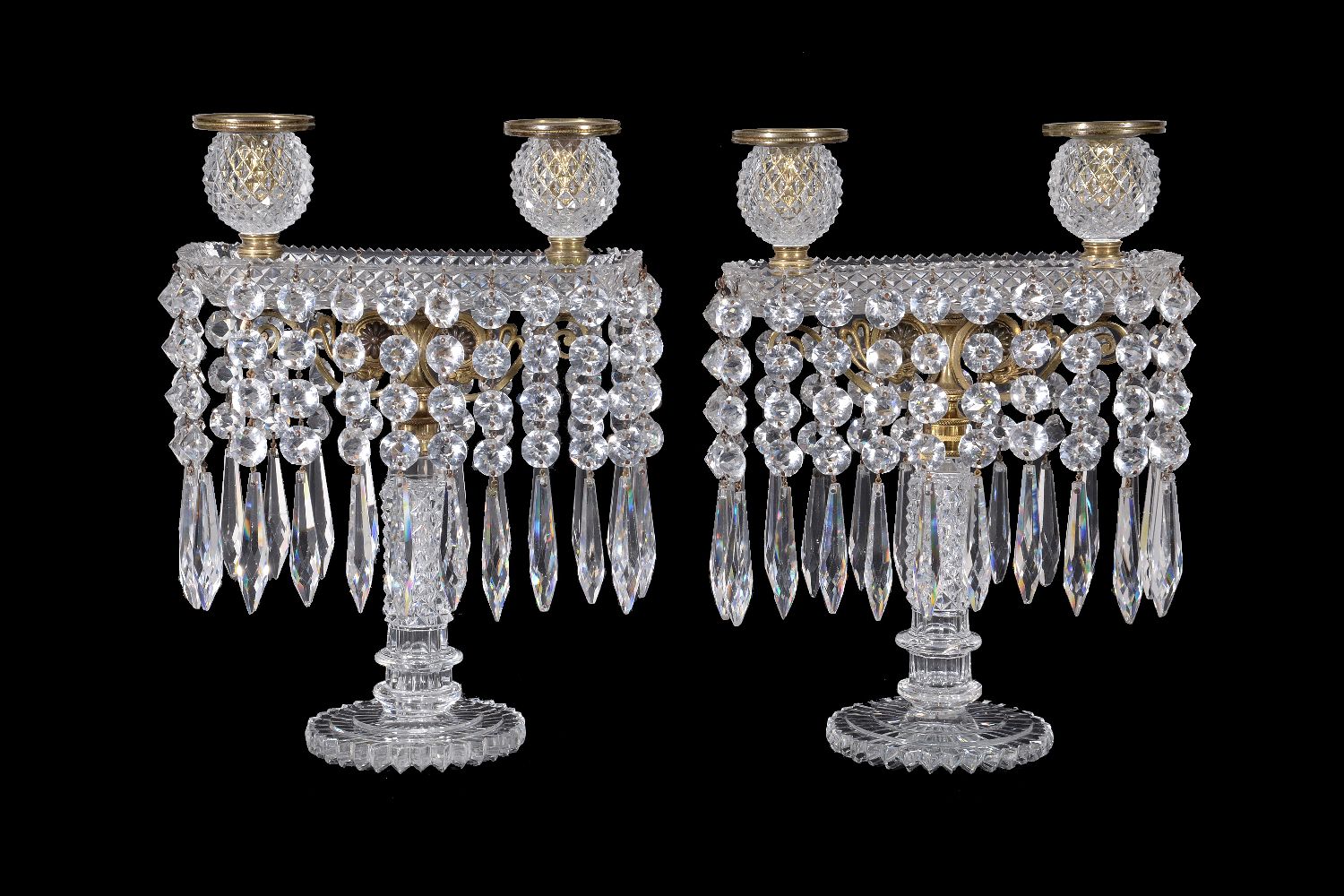 A fine pair of Regency cut glass and gilt metal mounted twin light lustre candelabra