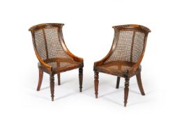A pair of George IV simulated rosewood and caned bergère chairs