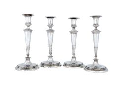 A set of four George III silver circular candlesticks by John Schofield