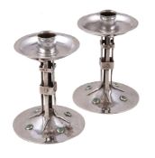 A pair of Arts and Crafts hammered silver candlesticks by Albert Edward Jones