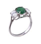 An emerald and diamond three stone ring