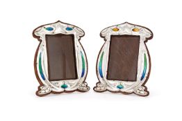 A matched pair of Arts and Crafts silver and enamel photograph frames by Charles S. Green & Co.