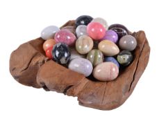 A collection of 30 polished marble and hardstone specimen eggs in a stained hardwood bowl