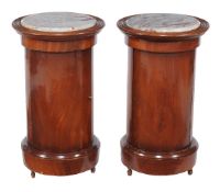 A pair of mahogany cylinder bedside cupboards