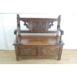 An Edwardian carved oak settle