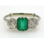 Platinum Ring with a centre oblong cut emerald flanked by two old cut diamonds,