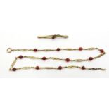 Early 20th century gold oval open link necklace interspersed with red stones,
