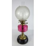 Table Oil Lamp with etched glass shade and cranberry glass reservoir on a circular base, H58cm.